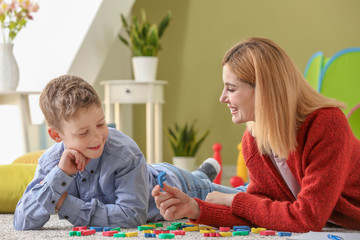 Female psychologist working with boy suffering from autistic disorder
