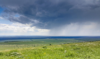 Beautiful summer rural landscape before a thunderstorm, against the blue sky.