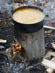 Pilaf in a cauldron on fire in the forest