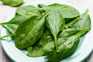 Plate with fresh spinach on table, closeup