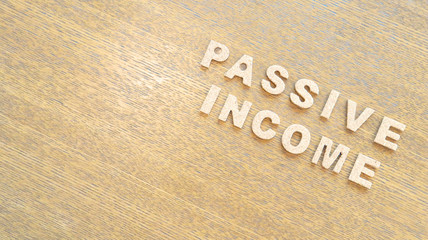 Cork Text Block of "Passive Income" on wooden table