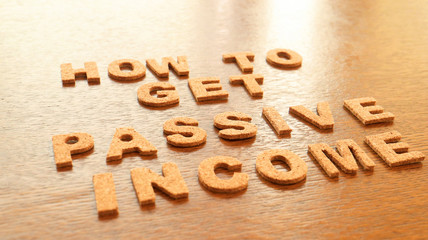 Cork Text Block of "Passive Income" on wooden table