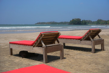 Fototapeta na wymiar Beautiful Sri Lankan view of the Indian Ocean with sun loungers on the beach. Summer holidays in Asia. Stock photos