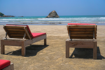 Beautiful Sri Lankan view of the Indian Ocean with sun loungers on the beach. Summer holidays in Asia. Stock photos