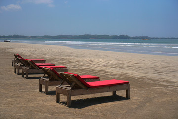 Beautiful Sri Lankan view of the Indian Ocean with sun loungers on the beach. Summer holidays in Asia. Stock photos