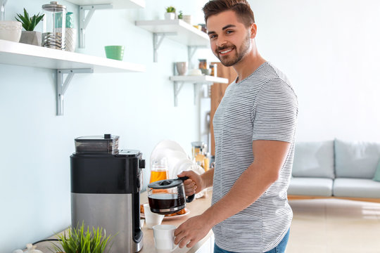 Handsome Man Using Coffee Machine In Kitchen