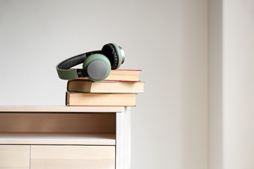 Books and modern headphones on table. Concept of audiobook