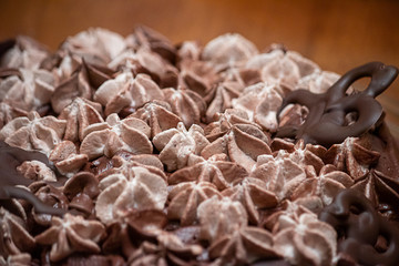 layers of varigated frosting on top of a thin single layer coffee flavored cake on a platter set on a table in a kitchen