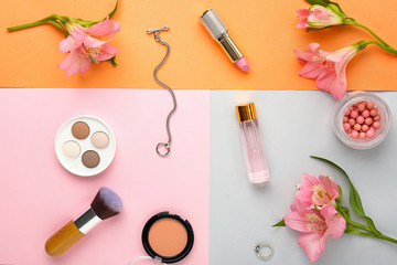 Obraz na płótnie Canvas Decorative cosmetics and flowers on color background