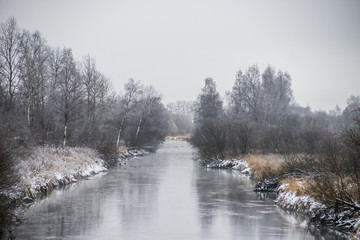 Winter landscape on the river. Snow picture. Snow and river. Cloudy snow day.