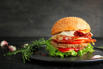 Tasty burger with bacon on plate