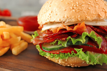 Tasty burger with bacon on table, closeup