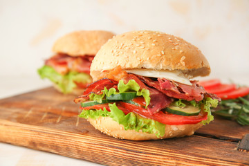 Tasty burger with bacon on board