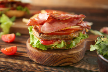 Tasty sandwich with bacon on table