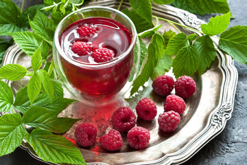 Berry juice in glass with fresh raspberries