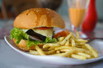 Burger and french fries on the table. Delicious food fast food. American food in a cafe