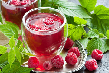 Glass of juice made of raspberries on silver tray