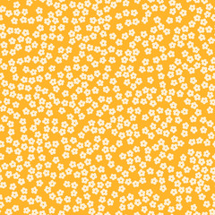Seamless cream ditsy flowers on a yellow background.