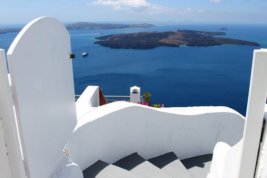 Santorini oia fira caldera view. White walls and stairs. Narrow street. Islands in the distance. - Powered by Adobe