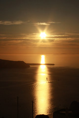 Sunset landscape. Thira oia santorini. Greek island scenic view of sea and little lonely sailboat.