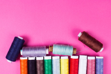 multicolored threads on a pink
