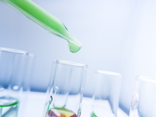 Pipettes take samples to a test tube containing chemicals.