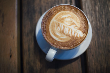 Top view of fresh coffee, latte art, coffee latte cup on a wood table.