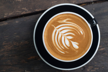 Top view of fresh coffee, latte art, coffee latte cup on a wood table.