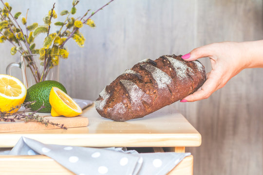 Woman puts homemade rye bread on the table