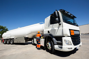 Fototapeta premium Camión cisterna con conductor revisando.