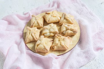 sweet pastry envelopes with cottage cheese in a wicker basket on a white background