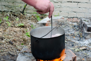 cooked soup in a cauldron on open fire