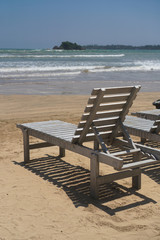 Beautiful Sri Lankan view of the Indian Ocean with sun loungers on the beach. Summer holidays in Asia. Stock photos