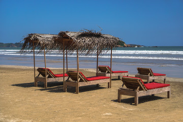 Beautiful Sri Lankan view of the Indian Ocean with sun loungers on the beach. Summer holidays in Asia. Stock photos
