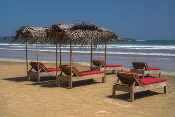 Beautiful Sri Lankan view of the Indian Ocean with sun loungers on the beach. Summer holidays in Asia. Stock photos