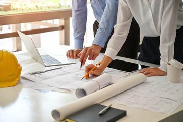 Architect meeting with blueprint on creative workspace.