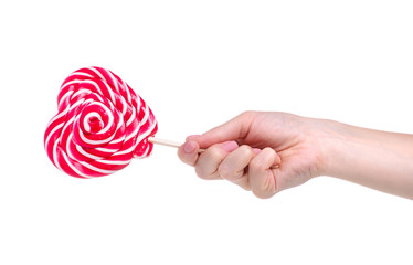 Candy lollipop heart in hand on white background isolation