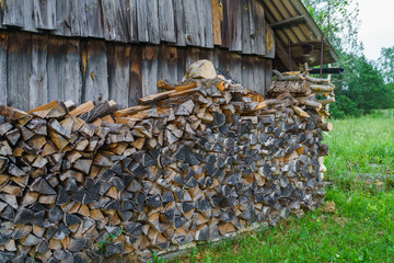 Fuel for stove heating at home and bath. Rural life. Wooden firewood is laid in the walls. Natural wood.