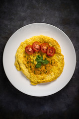 Omelette with tomatoes slide, coriander and scallion.
