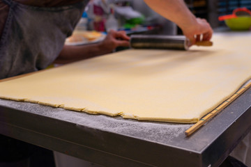Fototapeta na wymiar confectioner works the puff pastry dough, artisan, gourmet