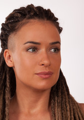 Portrait of a European girl with African braids and shaved temples on a white background