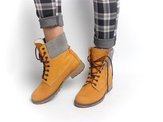 Women's legs in yellow shoes and checkered pants. Winter clothes.