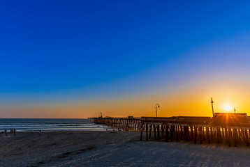 Obraz premium Sunset at the Beach over the Pier