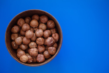 hazelnuts in a bowl on blue background