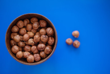 hazelnuts in a bowl on blue background