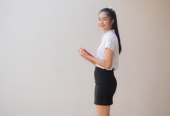 Portrait of thai adult student university uniform beautiful girl read red book