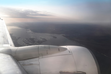 View from the airplane window on the river below. Tourist route to warm countries. The theme of the travel agency. Stock photo