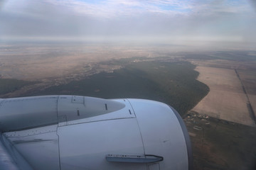 View from the airplane window on the river below. Tourist route to warm countries. The theme of the travel agency. Stock photo