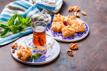 Traditional Turkish arabic dessert and a glass of tea with mint