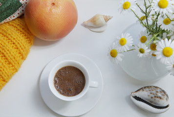 flat lay, white cup of coffee and orange grapefruit and white daisy flowers on a white background with design elements